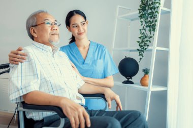 Caring nurse and a contented senior man in a wheel chair at home, nursing house. Medical for elderly patient, home care for pensioners.