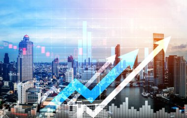 As background for a financial or business concept, digital screen and financial graphs overlap on a picture of modernistic cityscape, skyscrabbers.