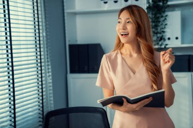 Young competent office lady, intern, secretary holding a log in office room. Concept of various career for office working. Concept of diverse office careers.