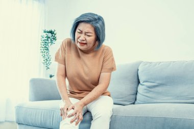 An agonizing elderly woman is experiencing chest pain. Medical attention, medical service for seniors.