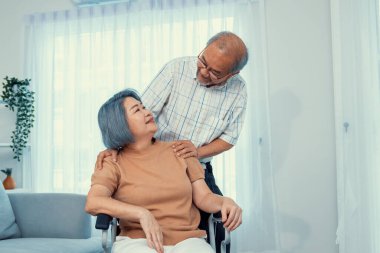 A contented senior couple and their in-home nurse. Elderly female in wheelchair with her young caregiver.