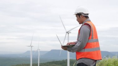 Kırsal kesimdeki bir tepenin tepesinde ya da dağda rüzgar çiftliğinde çalışan bir mühendis. Yenilenebilir ve sürdürülebilir enerjinin gelecekteki üretimi için yenilikçi bir ideal. Rüzgar türbininden enerji üretimi.