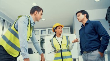 Engineers and competent employer discussing plans and blueprints together with tablet in the office. Concept of team contribution of ideas for engineering project.
