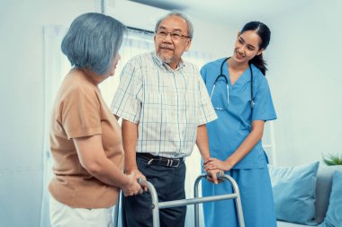 Contented senior man was helped on folding walking by his wife and caregiver. Recuperation for elderly, seniors care, nursing home.