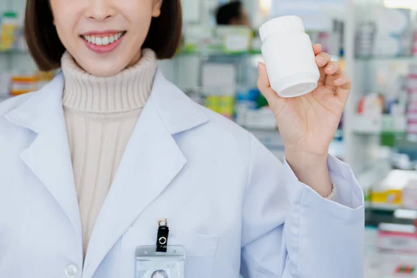 Primer Plano Joven Farmacéutico Afable Mostrar Medicamento Calificado Botella Botella —  Fotos de Stock