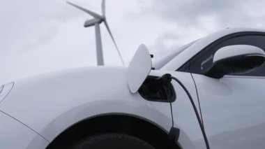 Çevreyi korumak için rüzgar türbininden yeşil ve yenilenebilir enerjiyle çalışan şarj istasyonunda şarj edilen gelişmiş gelecek enerji altyapısı konsepti.