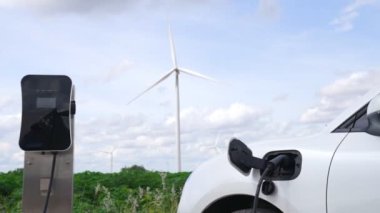 Çevreyi korumak için rüzgar türbininden yeşil ve yenilenebilir enerjiyle çalışan şarj istasyonunda şarj edilen gelişmiş gelecek enerji altyapısı konsepti.