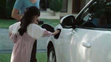 Evde şarj edilen elektrikli bir araçla okuldan yeni dönen anne ve kızın ilerici yaşam tarzı. Elektrikli araç, sürdürülebilir temiz enerjiyle çalışıyor..