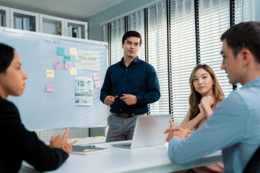 Competent office workers from various nationalities are debating, discussing and brainstorming in the meeting room. A group of employees is collaborating to achieve their business objectives.