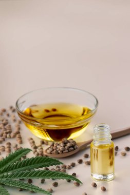 CBD yağı, cam kasede THC tintürü, damlalık kapaklı şişe ve boş arka planda kenevir yaprağı minimalizmle çevrili bir yığın kuru kenevir tohumu. Yasal marihuana konsepti.
