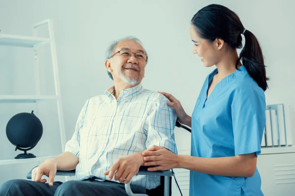 Happy Positive Asian Nurse Giving Support Touching Contented Senior Man — Stockfoto