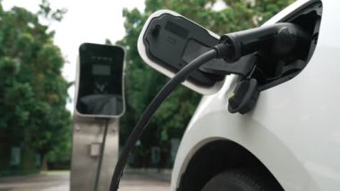 Elektrikli araba parkı ve şarj istasyonunun yanında şarj edilen enerji konseptinin sürdürülebilirliği. Çevresel koruma için yenilenebilir enerji tarafından kullanılan elektrikli araç.
