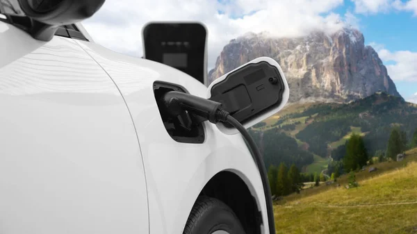 采用发电机驱动的可持续能源汽车动力 为具有山地背景的充电站充电蓄电池提供先进的旅行理念 大自然中的电动车是清洁环境的象征 — 图库照片