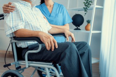 Caring nurse and a contented senior man in a wheel chair at home, nursing house. Medical for elderly patient, home care for pensioners.