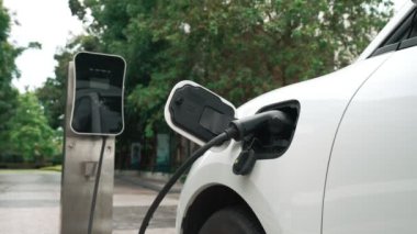 Elektrikli araba parkı ve şarj istasyonunun yanında şarj edilen enerji konseptinin sürdürülebilirliği. Çevresel koruma için yenilenebilir enerji tarafından kullanılan elektrikli araç.