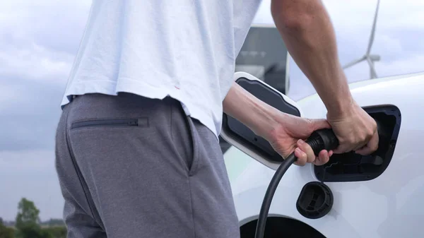 Прогрессивный Человек Заряжает Свой Автомобиль Зарядной Станции Питаемой Чистой Энергии — стоковое фото