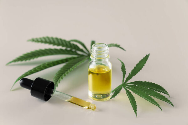 Лист конопли конопли конопли конопли с контейнером масла CBD с крышкой капельницы на белом фоне. Легализованная марихуана.