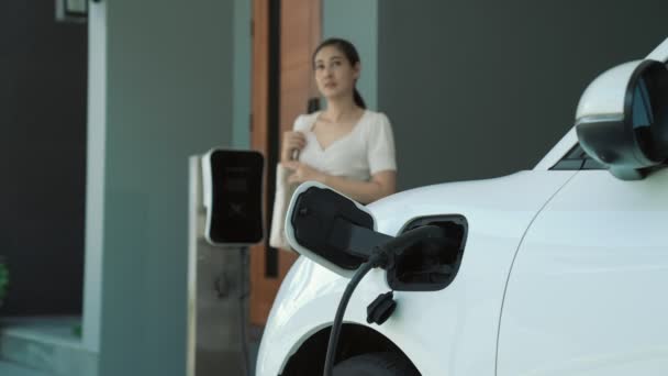 Bir Kadın Evinde Elektrikli Araç Şarj Aletinin Fişini Çekiyor Lerici — Stok video