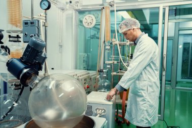 Kimyasal süreçleri kullanarak esrar, CBD yağı ve tentürleri çıkaran bir kimyager ya da eczacı. Tıbbi kenevir üretim tesisi. Kenevir yağı çıkarma makinesi ve ekipmanı.