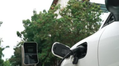 Elektrikli araba parkı ve şarj istasyonunun yanında şarj edilen enerji konseptinin sürdürülebilirliği. Çevresel koruma için yenilenebilir enerji tarafından kullanılan elektrikli araç.