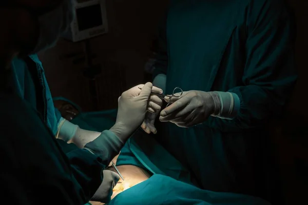 Obraz Zespołu Chirurgicznego Wykonującego Operację Pielęgniarka Rozdaje Chirurgowi Sterylne Nożyczki — Zdjęcie stockowe