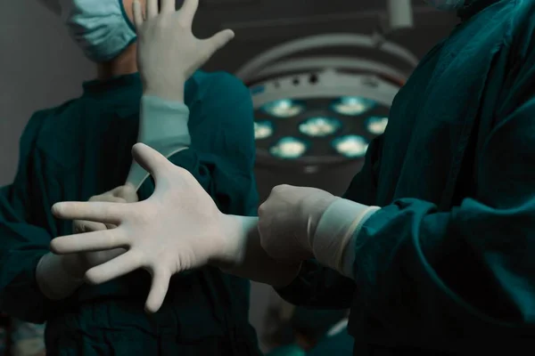 外科医は手術室で外科手術を行う前の準備として 保護滅菌手袋とマスクを着用します 医療利用のための手術準備コンセプト — ストック写真