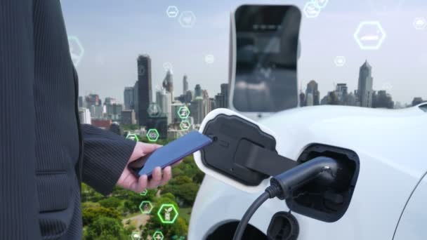 带有电动汽车的渐进式绿色城市Esg符号背景 在城市充电站 商人用充电器插头给电动汽车充电 带有环保标志和绿色标志 — 图库视频影像
