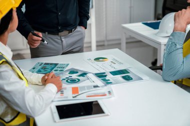 Engineers and competent employer discussing plans and blueprints together with tablet in the office. Concept of team contribution of ideas for engineering project.