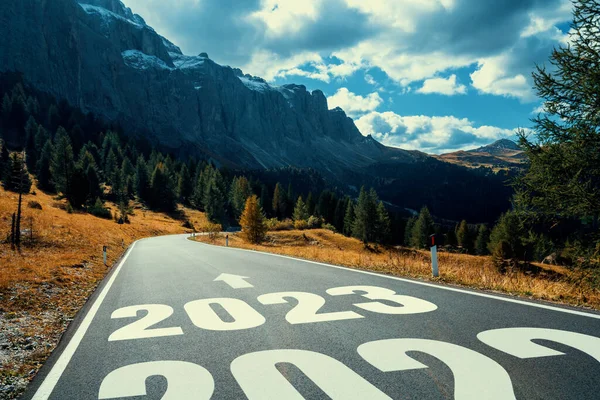 2023 New Year road trip travel and future vision concept . Nature landscape with highway road leading forward to happy new year celebration in the beginning of 2023 for fresh and successful start .
