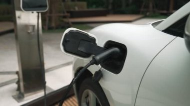 Elektrikli araba parkı ve şarj istasyonunun yanında şarj edilen enerji konseptinin sürdürülebilirliği. Çevresel koruma için yenilenebilir enerji tarafından kullanılan elektrikli araç.