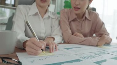 Ofis çalışma alanında birlikte çalışan iki genç hevesli iş kadını. Genç meslektaşlar tartışırken ve dizüstü bilgisayar kullanırken. Modern ofis çalışanları masada birlikte oturuyorlar..