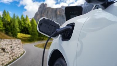 Elektrikli araç konsepti, yeşil çevre için yenilenebilir ve temiz enerjiyle çalışan EV otomobilinin varış noktasına ulaşmadan önce ormandaki şarj istasyonunun enerjisini şarj etmek için durur..