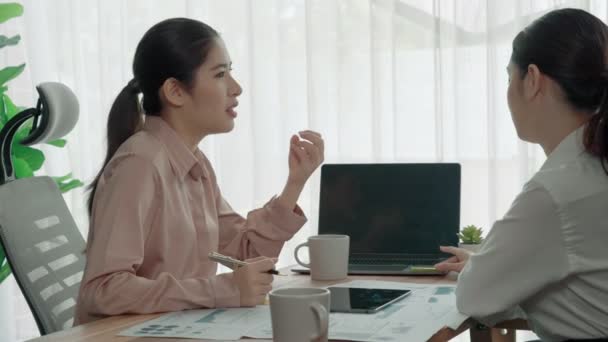 两个充满热情的年轻女商人在办公室里一起工作 年轻的同事一起讨论和使用笔记本电脑 现代办公室工作人员一起坐在办公桌前 — 图库视频影像