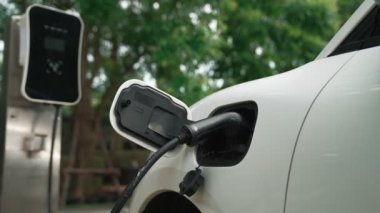 Elektrikli araba parkı ve şarj istasyonunun yanında şarj edilen enerji konseptinin sürdürülebilirliği. Çevresel koruma için yenilenebilir enerji tarafından kullanılan elektrikli araç.