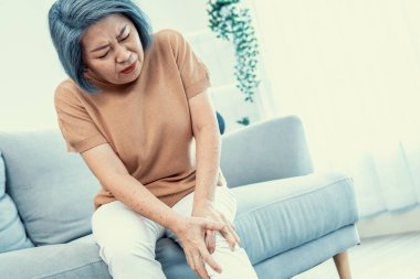 An agonizing elderly woman is experiencing chest pain. Medical attention, medical service for seniors.