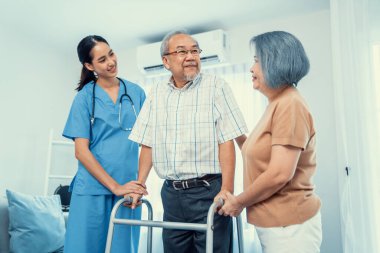 Contented senior man was helped on folding walking by his wife and caregiver. Recuperation for elderly, seniors care, nursing home.