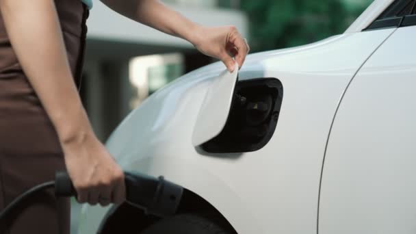 进步人士在家里的电动汽车上装了一个充电站插头 电动汽车提供了一个对环境有利的清洁和绿色能源概念 — 图库视频影像
