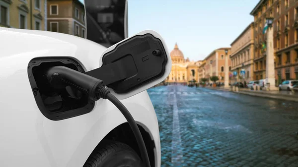 バチカンの充電ステーション 歴史的なキリスト教会 市内中心部で進歩的な電気自動車充電池 ケーブル電源プラグを介して充電ポイントに接続されたEv車 — ストック写真