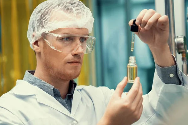 A scientist or apothecary extracts CBD hemp oil for medicinal purposes in a laboratory. Alternative cannabis-based medicine produced from cannabis extraction machine.
