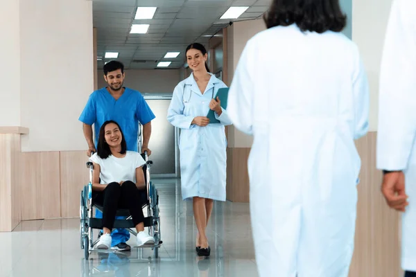 의사와 간호사는 복도를 휠체어를 환자를 신체장애자를 관리와 — 스톡 사진