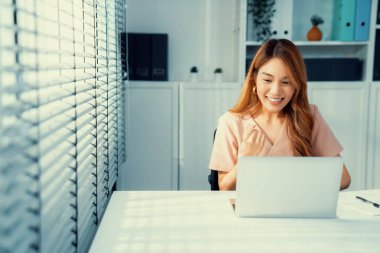 A young female employee receives a promotion, good news or finished her task and overjoyed for being a competent worker.