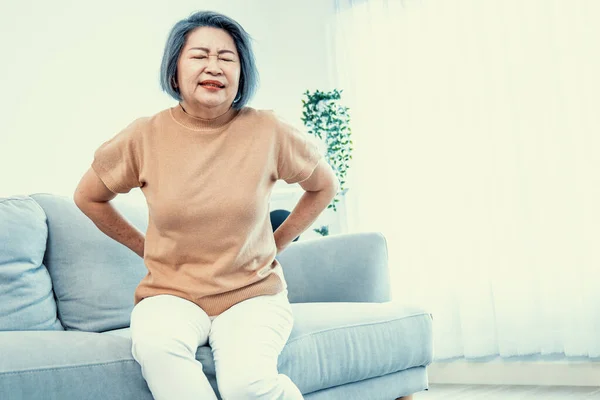 Agonizing Senior Woman Experiencing Back Pain While Sitting Her Sofa — Stock fotografie