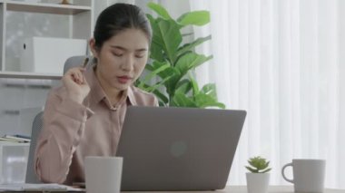 Ofiste çalışan ve dizüstü bilgisayar yazan hevesli bir iş kadını. Masasında oturmuş laptopla çalışan güzel bir ofis hanımı..