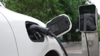 Elektrikli araba parkı ve şarj istasyonunun yanında şarj edilen enerji konseptinin sürdürülebilirliği. Çevresel koruma için yenilenebilir enerji tarafından kullanılan elektrikli araç.