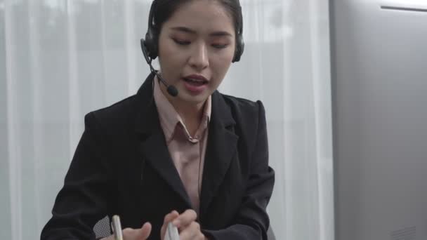 亚洲客户支持操作员戴着耳机和话筒 带着笔记本电脑在她的办公桌前工作 热心的女员工提供客户服务 支持呼叫中心代理帮助客户 — 图库视频影像
