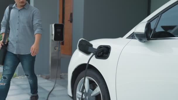 Een Man Haalt Stekker Uit Elektrische Auto Lader Zijn Huis — Stockvideo