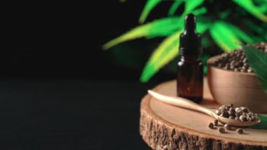 Ahşap kasede bulunan kenevir tohumu bahçedeki yetiştirilmiş kenevir bitkisinin bulanık arka planına sahip yasal yetiştirme tesisinde, kapalı alandaki kenevir tarlasında. Tıbbi amaçlar için kapalı alandaki çiftlikte kenevir tohumu..