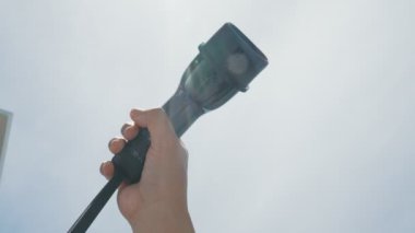 Yakın plan, çevresel kaygılar için alternatif sürdürülebilir temiz ve yeşil enerji kavramı olarak arka planda gün ortası gökyüzü ile elektrikli araç için bir EV kapsülü kavrıyor.