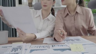 Ofis çalışma alanında birlikte çalışan iki genç hevesli iş kadını. Genç meslektaşlar tartışırken ve dizüstü bilgisayar kullanırken. Modern ofis çalışanları masada birlikte oturuyorlar..