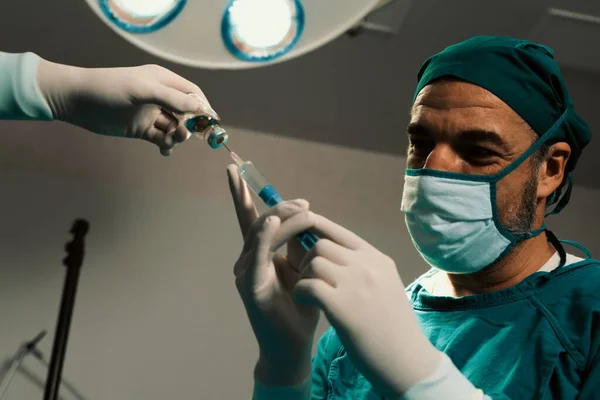 의사는 에서의 수술을 술병에서 주사기를 간호사와 채운다 수술을 완벽하게 의사와 — 스톡 사진
